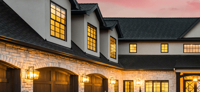 House with illuminated windows at sunset